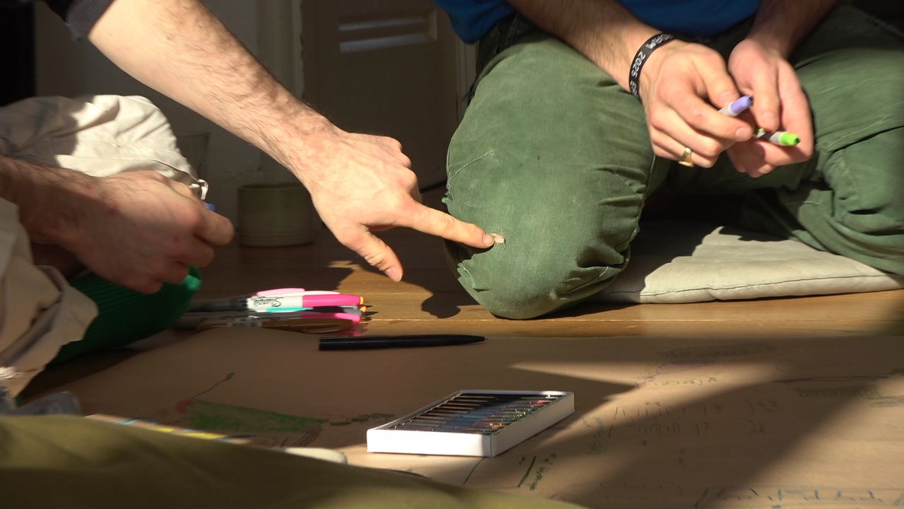 Elliott pointing at a whole in Gijs' trousers